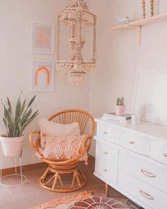 a living room with a chair, rug and chandelier hanging from the ceiling