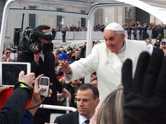 a man in white is surrounded by reporters and photographers as he walks through the crowd