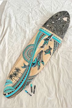 a surfboard laying on top of a bed covered in sheets and crayons