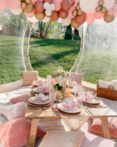 a table set up for a party with pink and gold balloons