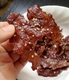 a person is holding up some food on a small white plate in front of them