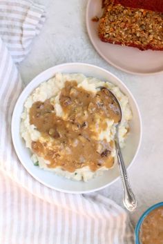 a plate with mashed potatoes, meatloaf and gravy