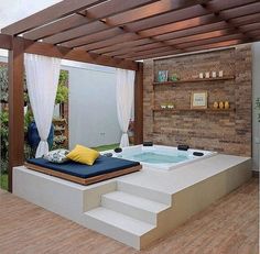 a hot tub sitting on top of a wooden floor next to a white stair case