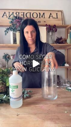 a woman sitting at a table with a bottle of liquid in front of her and the words como secar horsias con gliceria