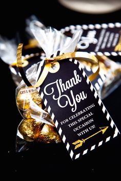 a black and white thank you tag with gold foiled candies in front of it