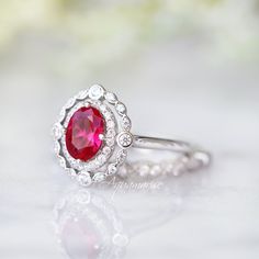 Beautiful Vintage Inspired Ruby Ring Made of Solid Sterling Silver, Rhodium Plated (925) Can be paired with one or two half-eternity Milgrain bands of your choice Accented with Simulated Diamonds (CZ) Center Stone: Ruby Grade: AAA Stone Cut: Oval Gem size: 7.0 x 5.0 mm Carat Weight: 0.76 (approx.) Gemstone creation: 100% Genuine Lab-Grown Ruby Stone Origin: Russia Handling time: 1-2 business days Free domestic shipping. Usually takes 2-5 business days. Wrapped & ready to give in a beautiful Classic Promise Ring With Lab-created Ruby, Classic Lab-created Ruby Rings For Promise, Classic Jewelry For Proposal With Accent Stones, Classic Proposal Jewelry With Accent Stones, Classic Halo Design Jewelry For Proposal, Classic Ruby Ring With Halo Design, Timeless Ruby Rings For Wedding, Classic Round Band Lab-created Ruby Jewelry, Classic Lab-created Ruby Round Band Jewelry