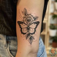 a woman's arm with a butterfly and rose tattoo on the left side of her arm