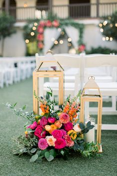 an arrangement of flowers and lanterns on the grass