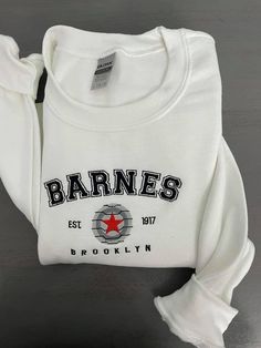 Barnes 1917 Embroidered Sweatshirt Celebrate timeless style and heritage with the Barnes 1917 Embroidered Sweatshirt. Featuring elegant embroidery that proudly showcases "Barnes 1917," this sweatshirt combines vintage-inspired design with modern comfort, making it a versatile staple for any wardrobe. Crafted from a premium cotton-poly blend, it offers a soft, cozy feel with durability that lasts. The relaxed fit and ribbed cuffs and hem provide a polished yet comfortable silhouette, perfect for White Fleece Sweatshirt With Embroidered Logo, White Collegiate Sweatshirt With Custom Embroidery, White Crew Neck Hoodie With Letter Embroidery, White Sweatshirt With Custom Embroidery, Relaxed Fit, White Sweatshirt With Custom Embroidery In Relaxed Fit, Custom Embroidered Crew Neck Hoodie For College, Varsity Sweatshirt With Custom Embroidery For Streetwear, Sporty Crew Neck Sweatshirt With Custom Embroidery, White Varsity Sweatshirt With Embroidered Graphics