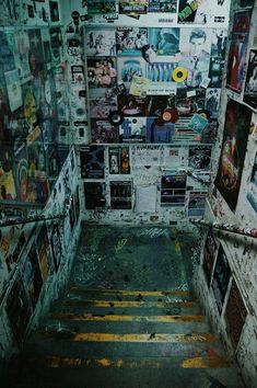 the stairs are covered with pictures and posters in an abandoned building that has been vandalized