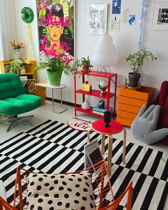 a living room filled with lots of furniture and colorful accessories on top of a black and white checkered floor