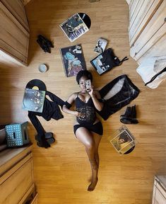 a woman laying on the floor talking on her cell phone with other items surrounding her