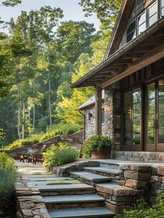 a house with stone steps leading up to the front door and patio area, surrounded by greenery