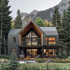 a house in the woods with mountains in the background