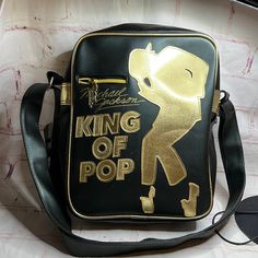 a black and gold bag with the words king of pop written on it's side