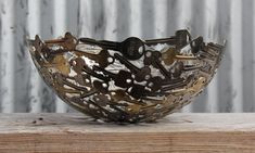 a metal bowl sitting on top of a wooden table