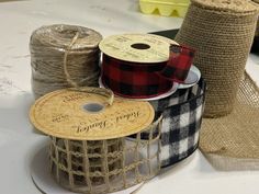 three rolls of burlap twine on top of each other next to two spools of twine