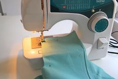 the sewing machine is being used to sew fabric on it's own arm