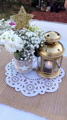 a vase filled with flowers sitting on top of a table next to a lit candle