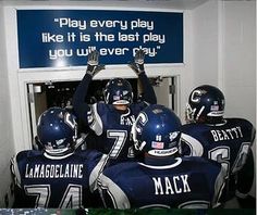 there are some football players that are in the locker room with their arms up and hands raised