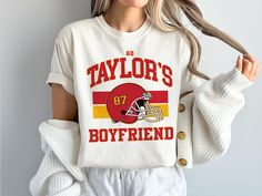 Show your support for Taylor's Boyfriend this football season!  This Comfort Colors Shirt is made to look vintage with a distressed inspired style.  Shirt does not come oversized. For an oversized look, size up one or two sizes!   Please note our production is usually 2-5 days before the items ship and we will do our best to get everything out right away. Every item is custom produced, made to order, so please note each item is unique and may differ in color slightly from photos, which is what m Taylor Boyfriend, Football Lover, Football Tee, Oversized Look, Meme Design, Football Lovers, Football Tees, Comfort Colors Shirt, Boyfriend T Shirt