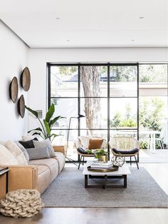 a living room filled with furniture and a tree in the middle of it's wall