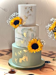 3 tier sage green wedding cake with marble, gold leaf and fresh sunflowers Yellow And Green Wedding Cake, Sunflower Cake Designs Birthday, Sunflower Theme Cake, Sunflower Wedding Colors, Sunflower Wedding Cupcakes, Wedding Cake With Sunflowers, White And Sage Green Wedding, Sage Green Wedding Cake