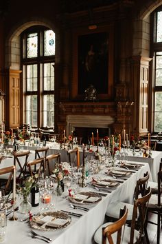 a long table is set up with place settings and candles for an elegant wedding reception