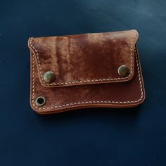 a brown leather wallet sitting on top of a blue surface