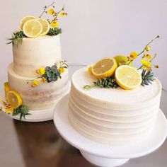 two tiered cake with lemons and greenery on the top, next to each other