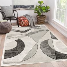 a living room area with a rug, chair and potted plant