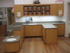 an empty kitchen with wooden floors and cabinets