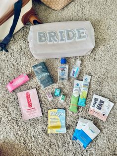 the contents of a bride's bag laid out on the floor next to her purse