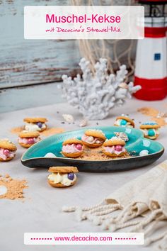 there is a plate with mini sandwiches on it next to other small cookies and marshmallows