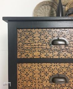 the drawers are decorated with black and brown designs on them, along with wicker baskets