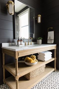 a white toilet sitting next to a sink in a bathroom under a mirror and framed pictures