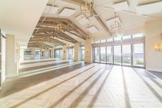 an empty room with large windows and wood flooring on the walls is pictured in this image