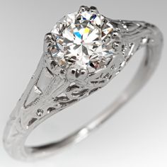 an antique style diamond ring with filigrees on the band and center stone