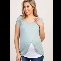 a pregnant woman wearing a blue top with an asymmetrical design on it