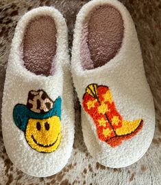 Here’s some fun slippers for the Cowgirls and Cowgirls at heart! These comfy slippers feature a Smiley Face Cowboy and Cowboy Boots. They're incredibly comfy, extra cozy, and feature a rubber bottom ideal for indoor and outdoor wear.Very limited quantity - don't miss out on these fun slippers! Sizing Information:This item is based on women's sizing, and men should size up for the best fit. Size Chart: 6/7: Length 9" 7/8: Length 9 3/4" 8/9: Length 10" 9/10: Length 10 1/2" 11/12: Length 10 3/4" Be Cute Multicolor Slippers With Round Toe, Cute Round Toe Slippers For Leisure, Fun Round Toe Slippers For Winter, Playful Winter Slip-on Slippers, Fun Round Toe Winter Slippers, Cute Indoor Slippers With Round Toe, Fun Slippers With Soft Sole And Round Toe, Super Soft Comfy Slippers With Round Toe, Comfy Super Soft Round Toe Slippers