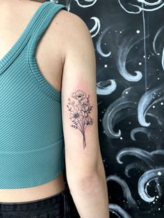 a woman with a flower tattoo on her left arm and the back of her shoulder