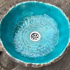 a sink that is sitting on top of a wooden table with water running down it