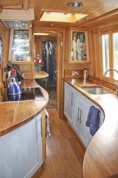 a kitchen area with wooden counter tops and white cabinets, along with an island in the middle