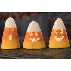 three pumpkin shaped candles sitting on top of a wooden table