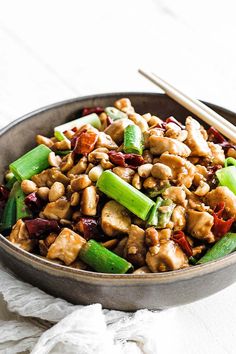 a close up of a bowl of food with chopsticks