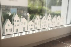 a window with white houses and stars drawn on it