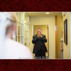 a man standing in front of a mirror holding his hands to his mouth and looking into the mirror