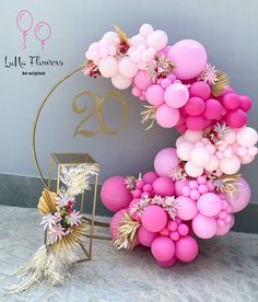 the balloon arch is decorated with pink and gold balloons, flowers and tassels