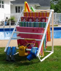 a towel rack with towels and toys in it next to a swimming pool that has the words flight bar towel rack on it