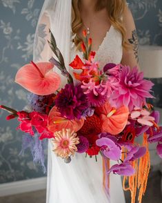 a woman in a wedding dress holding a large bouquet with flowers on it's side